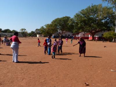 Children and moms enjoying light moment playing traditional games.